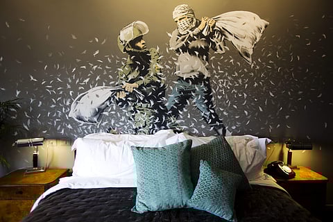 A Banksy wall painting showing Israeli border policeman and Palestinian in a pillow fight is seen in one of the rooms of the 'The Walled Off Hotel' in the West Bank city of Bethlehem, Friday, March 3, 2017. (Photo | AP)