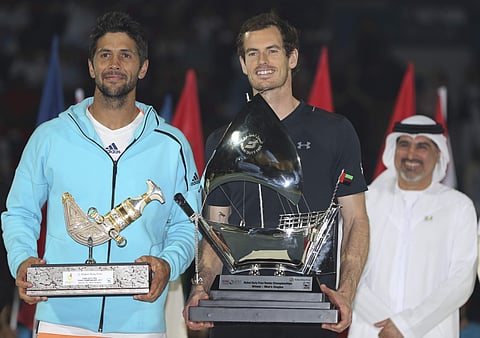 Salah Tahlak, Executive Vice President Corporate Services Dubai Duty Free, and Tournament Director, 1st right, looks on as Andy Murray of Great Britain, middle, holds the trophy next to Fernando Verdasco of Spain after he beats him during the final match 