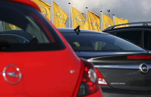 Flags with the Opel company logo wave outside the automaker's assembly plant in Antwerp . (Reuters)