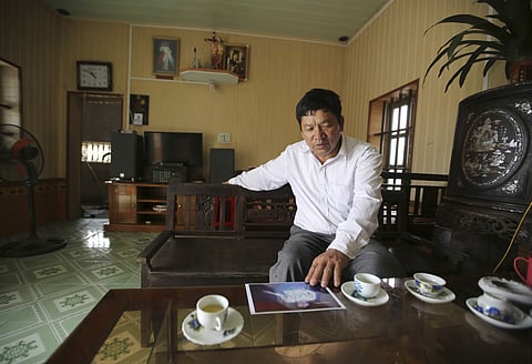 Doan Van Thanh, the father of a Vietnamese woman arrested in the death of Kim Jong Nam in Malaysia, looks at an image of his daughter. (File Photo | AP)