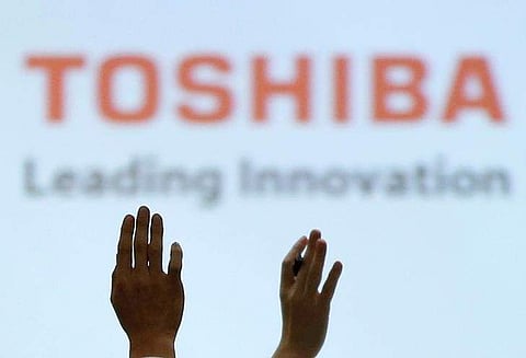 Reporters raise their hands for a question during a news conference by Toshiba Corp CEO Satoshi Tsunakawa (Photo | Reuters)