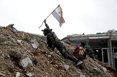 A Syrian army soldier places a Syrian national flag during a battle with rebel fighters east of Aleppo. (File Photo | AP)