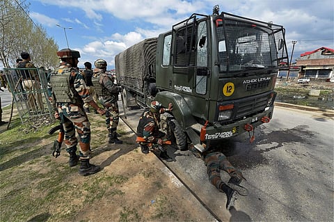 Soldiers keep vigil as an army jawan checks a military truck for damages which was targeted by militants near a hospital along Parimpora-Panthachowk bypass road in Srinagar on Saturday. Two soldiers were injured in the attack but the militants fled away i