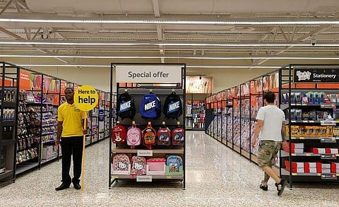 A customer service representative stands in an aisle at a Tesco Extra supermarket in Watford, north of London. (File Photo | Reuters)