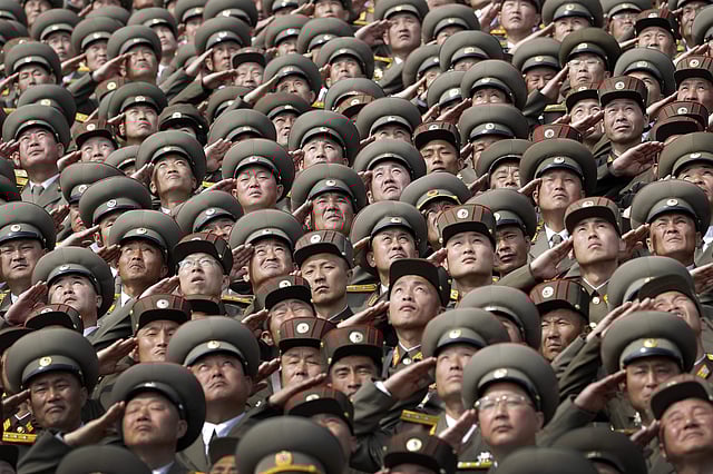 North Korean soldiers salute while the national anthem is played during the military parade on Saturday. | AP