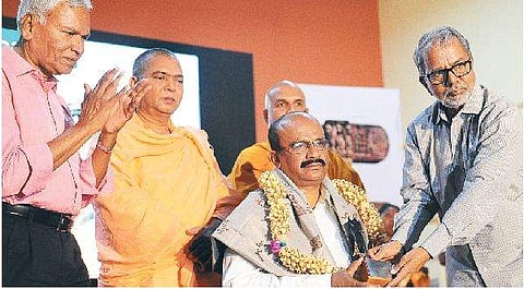 Writer and activist Dr K Marulasiddappa presenting the Bodhivardhana award to senior Telugu journalist Mallepalli Laxmaiah in Bengaluru on Friday. Spoorthidhama Trust chairman Mariswamy and Veerabhadra Channamalla Swamiji of Nidumamidi Mutt look on | NAGE