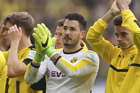 In this April 15, 2017 photo Dortmund's goalkeeper Roman Buerki und Raphael Guerreiro, right, cheer towards their fans after the German Bundesliga soccer match between Borussia Dortmund and Eintracht Frankfurt in Dortmund, Germany. | AP