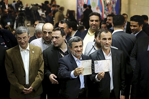 Former Iranian President Mahmoud Ahmadinejad, center, and his close ally Hamid Baghaei, right, show their identifications after registering their candidacy for the upcoming presidential elections at the Interior Ministry to , in Tehran, Iran. (File photo 