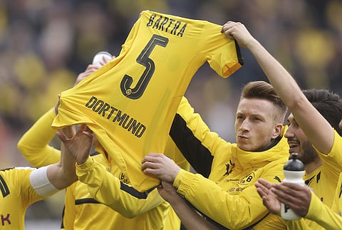 Dortmund's Marco Reus, Nuri Sahin, right, and other players hold up the jersey of teammate Marc Bartra after the German Bundesliga soccer match between Borussia Dortmund and Eintracht Frankfurt in Dortmund. | AP