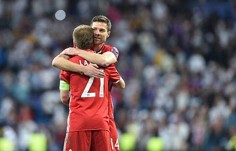 Bayern Munich's defender Philipp Lahm (L) hugs teammate Xabi Alonso (R) after their UEFA Champions League quarter-final second leg football match against Real Madrid. (Photo | AFP)