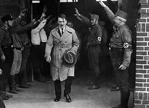In this Dec. 5, 1931 file photo, Adolf Hitler, leader of the National Socialists, is saluted as he leaves the party's Munich headquarters. | AP