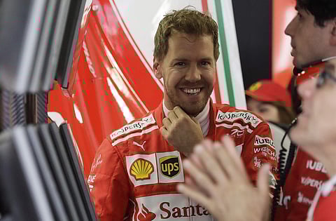 Ferrari driver Sebastian Vettel of Germany smiles in the Ferrari box during the first practice session ahead the Formula One Russian Grand Prix. | AP