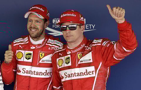 Ferrari drivers Sebastian Vettel of Germany, left, and Kimi Raikkonen of Finland gesture as they pose for photos at the end of the qualifying session ahead the Formula One Russian Grand Prix at the 'Sochi Autodrom' circuit. | AP