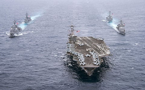 In this Wednesday, April 26, 2017 photo released by the U.S. Navy, the aircraft carrier USS Carl Vinson, center, leads the U.S. Navy guided-missile cruiser USS Lake Champlain, right front, and the Arleigh Burke-class guided-missile destroyer USS Michael M