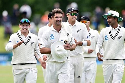 New Zealand's Colin de Grandhomme (C) walks from the field at the end of the Pakistan innings with six wickets during day two of the first cricket Test match between New Zealand and Pakistan. | AFP