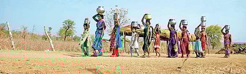 Women trudge up a hill in Ratnapur that is the lone source of drinking water for the villagers. | (Satya Keerthi | EPS)