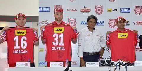 Kings XI Punjab players Eoin Morgan Martin Guptil and Virendra Sehwag at the launch of their team jersey in Indore on Tuesday. | PTI