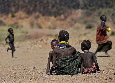 A Turkana woman waits with her children to get food rations near Lokitaung in northern Kenya's Turkana county where a biting drought has ravaged livestock population on March 21, 2017.(AFP)