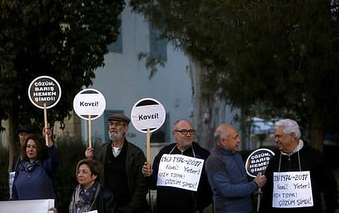 Greek and Turkish Cypriots hold banners reading in Greek and Turkish 'Solution Now' and 'Enough'. (File photo | AP)