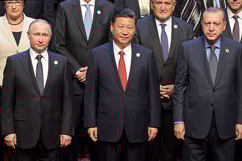 Chinese President Xi Jinping, center, stands with Russian President Vladimir Putin, left, Turkish President Recep Tayyip Erdogan, right, and other leaders to pose for a group photo prior to the opening ceremony of the Belt and Road Forum at the China National Convention Center in Beijing Sunday, May 14, 2017.