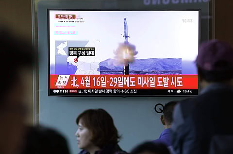People watch a TV news program showing a file image of a missile launch conducted by North Korea. (AP)