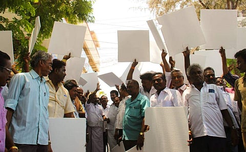 The transport employees are seen staging a protest protest by holding thermocol sheets condemning the Minister for Cooperation Sellur K Raju at PRC depot at Palanganatham in Madurai on Monday (EPS|KK Sundar)