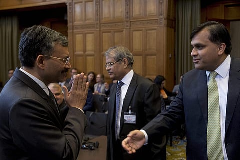 Dr. Deepak Mittal joint secretary of India's Ministry of External Affairs left greets Pakistan's Syed Faraz Hussain Zaidi as they wait for judges to enter the World Court in The Hague Netherlands Monday May 15 2017. | AP