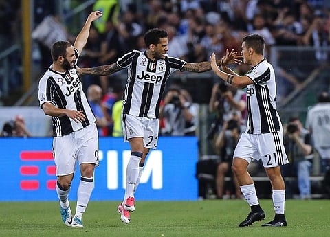 Juventus' Dani Alves, center, celebrates with his teammates Paulo Dybala, right, and Gonzalo Higuain after scoring during the Italian Cup final soccer match between Lazio and Juventus, at the Rome Olympic stadium, Wednesday, May 17, 2017. | AP
