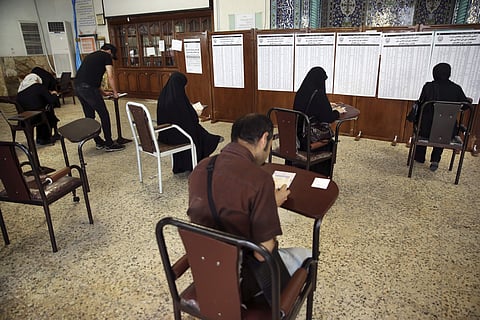 ranian voters fill in their ballots while voting for the presidential and municipal council election in Tehran, Iran, Friday, May 19, 2017.(AP)