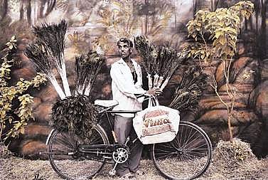© Waswo X. Waswo, Feathers for Sale, 2008, Black and white pigment print hand-coloured by Rajesh Soni Courtesy Tasveer