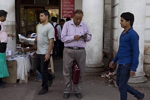 Man checks his phone at New Delhi's Connaught Place. (Photo|AP)