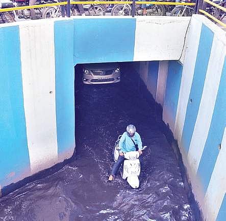 A two-wheeler rider passes through a magic box clogged with rainwater between Cunningham Road and Sankey Road on Friday | Pushkar V