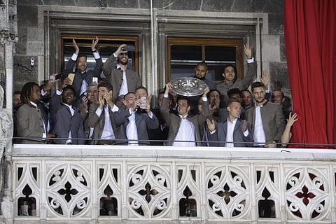 Bayern's Philipp Lahm lifts the trophy as his team celebrate on the balcony of the town hall at Marienplatz square after winning the 27th Bundesliga title at the German first division Bundesliga soccer match between FC Bayern Munich and SC Freiburg at the