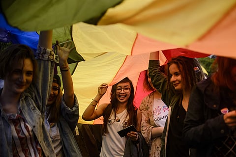 People walk holding a large rainbow flag during a Gay Pride Parade in Bucharest, Romania, Saturday, May 20, 2017. | AP