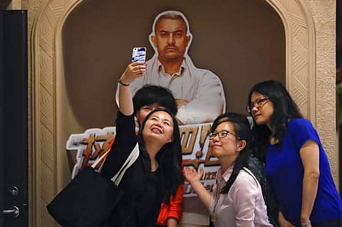 In this Monday, May 22, 2017 photo, a group of Chinese women take a selfie with a poster of Indian Bollywood blockbuster film 'Dangal' on display at a cinema in Beijing. (Photo | AP)
