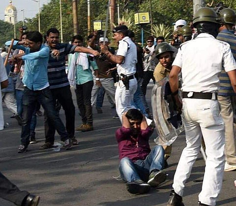 A journalist holds his head in pain during a lathi-charge by policemen during Left Front's 'Nabanna Avijaan' on Mayo Road in Kolkata on Monday | Express Photo Service