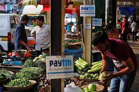 Advertisement boards of Paytm, a digital wallet company, are seen placed at stalls of roadside vegetable vendors as they wait for customers in Mumbai. (File | Reuters)