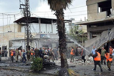 In this photo released by the Syrian official news agency SANA, Syrian security forces and firefighters gather at the scene of an explosion, in the central city of Homs, Syria, Tuesday, May 23. (Photo | AP)