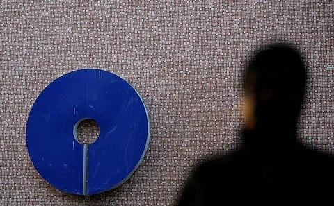 A man walks past a logo of State Bank of India outside a branch in New Delhi in February 2017. (File photo | Reuters)