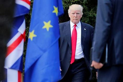US President Donald Trump arrives to pose for a family photo with participants of the G7 summit. (Photo | AFP)