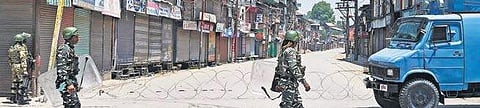 Security personnel stand guard during curfew in Srinagar on Sunday. Authorities imposed curfew in parts of the Valley following the killing Hizbul commander Sabzar Bhat on Saturday | PTI
