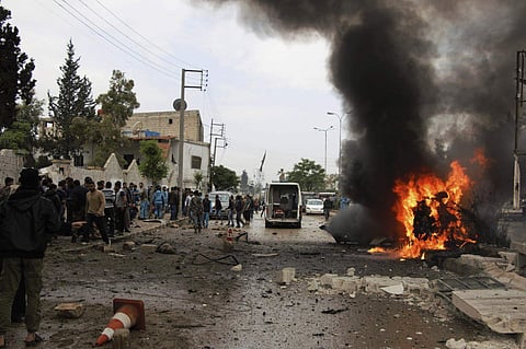 Syrian citizens and civil defense workers gathering next of burning car at the explosion scene, in Azaz town, north Syria, Wednesday, May 3, 2017. (Photo|Associated Press)