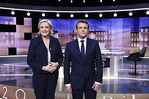 French presidential election candidate for the far-right Front National party, Marine Le Pen, left, and French presidential election candidate for the En Marche ! movement, Emmanuel Macron, pose prior to the start of a live broadcast face-to-face televise