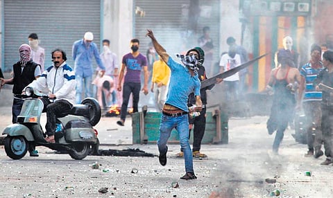 A protestor hurling stones at security forces in Kashmir