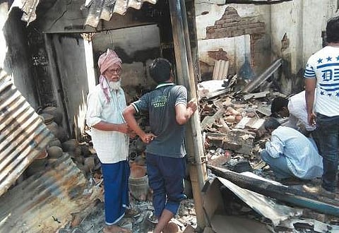 Shakeel in his shop damaged in the violence| Express