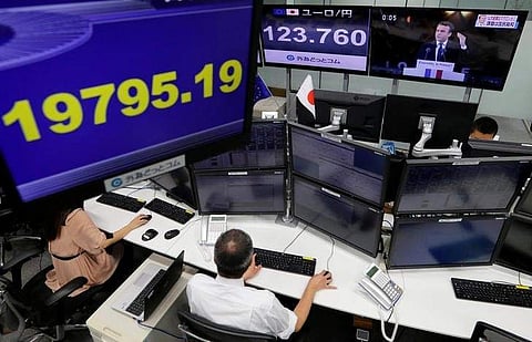 Employees of a foreign exchange trading company work near monitors showing French President-elect Emmanuel Macron (top R) on TV news, the Japanese yen's exchange rate against the euro (C) and Japan's Nikkei average in Tokyo, Japan, May 8, 2017. | Reuters