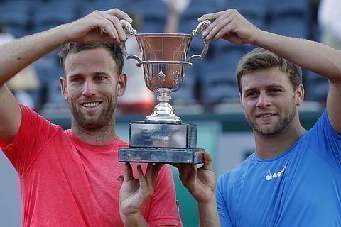 Ryan Harrison of the U.S. and Michael Venus of New Zealand, left, hold the trophy after winning the men's doubles title at French Open in the Roland Garros stadium, in Paris. | AP