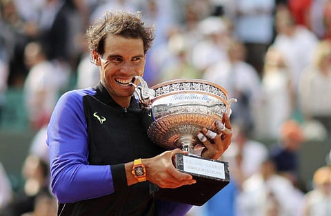 Spain's Rafael Nadal bites the cup after defeating Switzerland's Stan Wawrinka in their final match of the French Open tennis tournament at the Roland Garros stadium. | AP