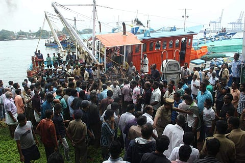 A huge crowd, comprising fishermen and media look on as a boat reached Fort Kochi with a body early on Sunday. | (File photo by EPS | Melton Antony)