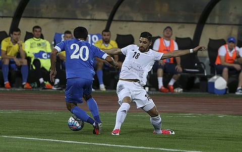Iran's Alireza Jahan Bakhsh, right, defends against Uzbekistan's Akmal Shorakhmedov during their 2018 Russia World Cup qualifying soccer match at the Azadi Stadium in Tehran, Iran, Monday, June 12, 2017. | AP